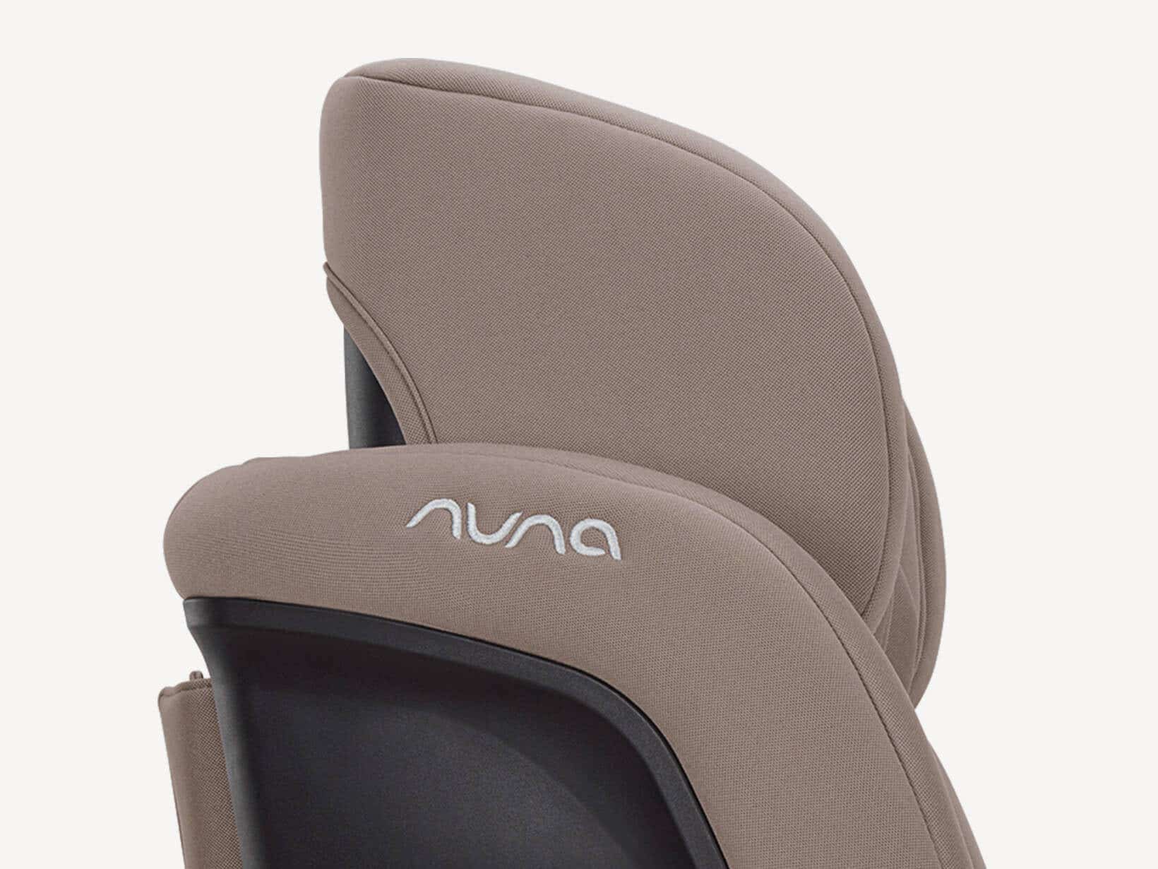 Close-up of the padded Nuna RAVA next headrest wing in soft taupe fabric with embroidered nuna logo